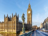 Photo of the Houses of Parliament and Big Ben, taken from Westminster bridge, with a bright blue sky.