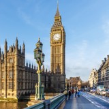 Photo of the Houses of Parliament and Big Ben, taken from Westminster bridge, with a bright blue sky.
