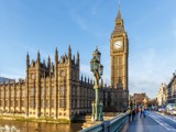 Photo of the Houses of Parliament and Big Ben, taken from Westminster bridge, with a bright blue sky.