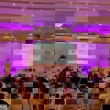Photo of Sanchita speaking at conference with slides in background