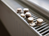 Photo focused on the top of a radiator, with coins piled on the top grate.