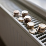 Photo focused on the top of a radiator, with coins piled on the top grate.