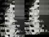 Black and white photo of woman in checked shirt smiling at camera