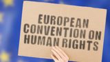 A sign being held up which reads: "European Convention on Human Rights"