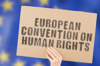 A sign being held up which reads: "European Convention on Human Rights"