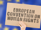 A sign being held up which reads: "European Convention on Human Rights"