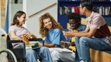 Photo of 4 young people in a college sitting and talking. 