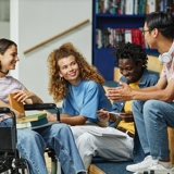 Photo of 4 young people in a college sitting and talking. 
