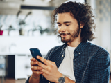 Man holding and looking at his mobile phone, with a blurred background