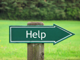 A green signpost, outdoors, which read "Help"