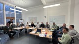 Photo of workshop participants sitting around table and smiling