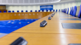 Photo of the inside of the European Court of Human Rights (empty), with the view looking down the desks the judges are at.